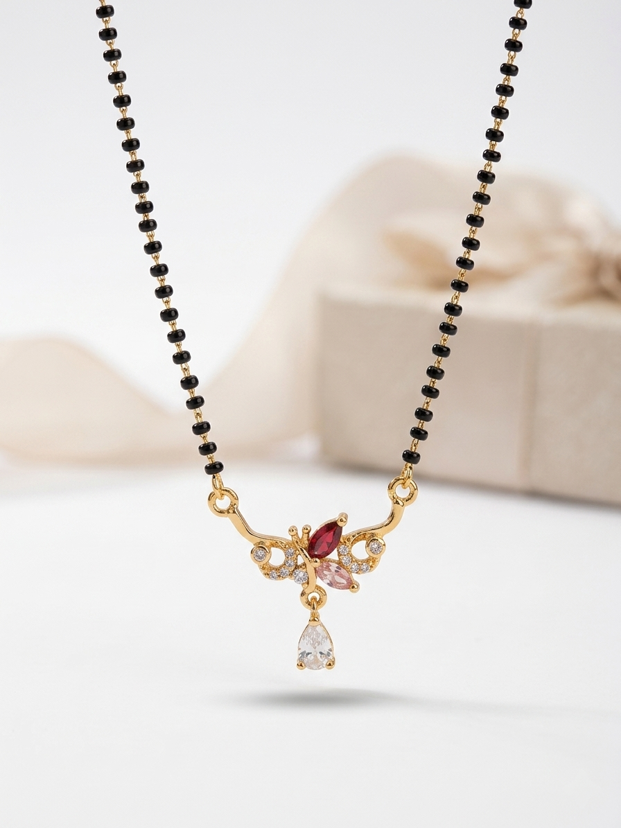 Necklace with black beads and a gold pendant featuring gemstones on a light background