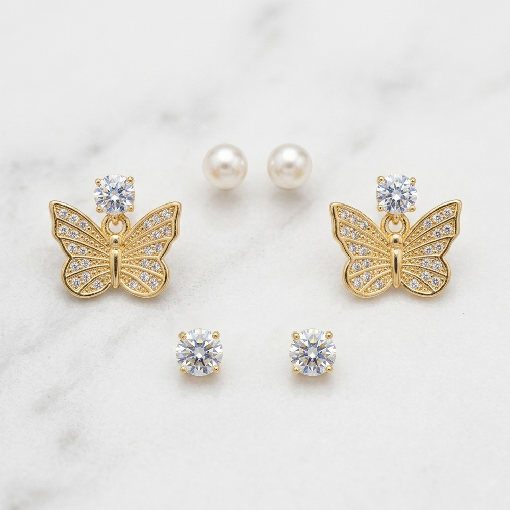 Butterfly-shaped earrings with gemstones on a light background