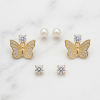Butterfly-shaped earrings with gemstones on a light background