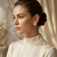 Woman wearing butterfly earrings with a neutral background