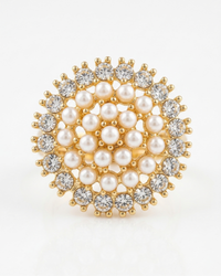 Gold brooch with pearls and crystals on a white background