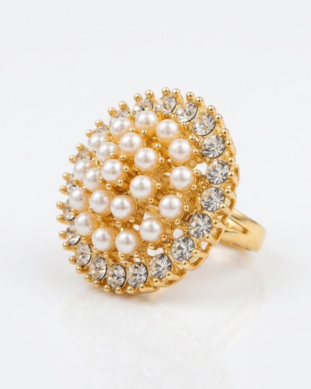 Gold ring with pearl and crystal embellishments on a white background