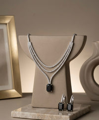 Jewelry set with necklace and earrings on a display stand against a neutral background