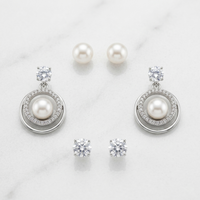 Pearl and crystal earrings on a light background