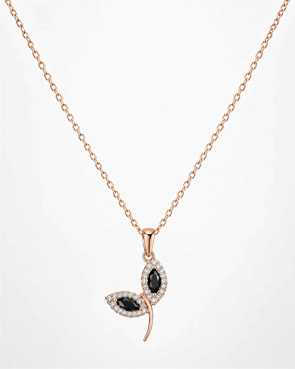 Rose gold necklace with a leaf-shaped pendant featuring black stones on a white background
