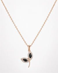 Rose gold necklace with a leaf-shaped pendant featuring black stones on a white background