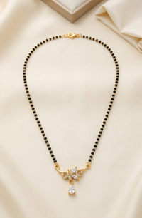 Black beaded necklace with gold accents on a beige fabric background