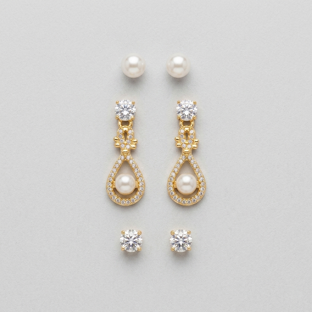 Gold earrings with pearls and crystals on a light gray background