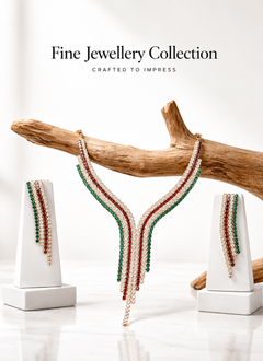 Fine jewellery collection with a necklace on a wooden branch against a white background