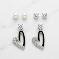 Heart-shaped earrings with black and clear stones on a white background