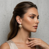 Woman wearing a star-shaped earring against a neutral background