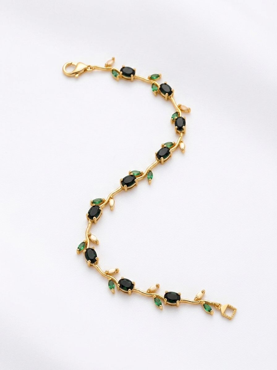 Gold bracelet with green gemstones on a white background