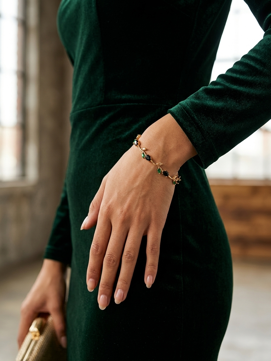 Person wearing a green dress with a bracelet, holding a gold clutch.