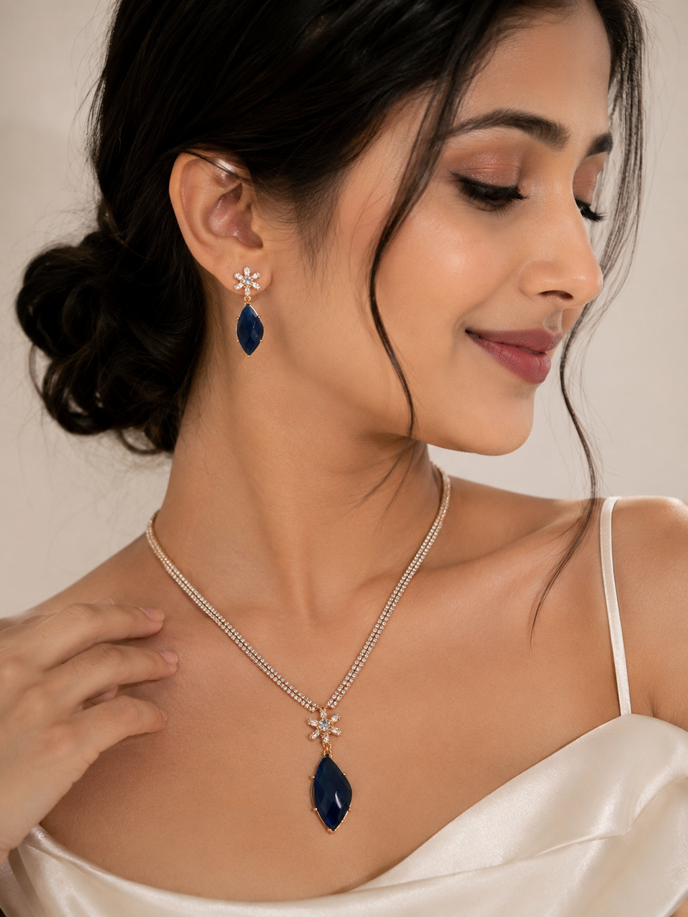 Woman wearing a necklace and earrings with a neutral background