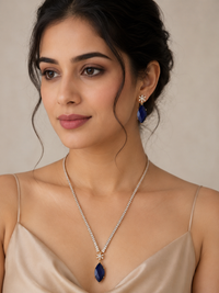 Woman wearing a necklace and earrings with a neutral background