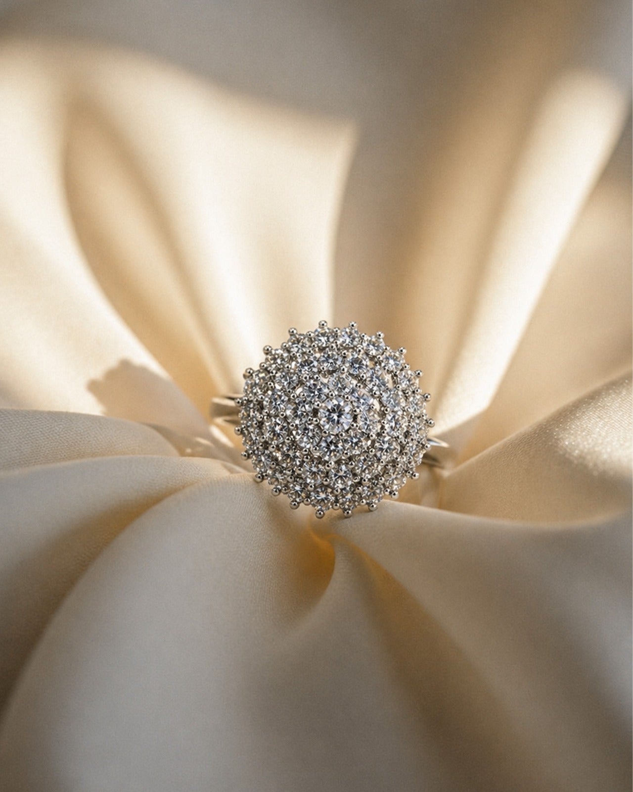 Silver ring with intricate design on a cream fabric background