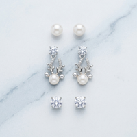 Pearl and crystal earrings on a marble surface