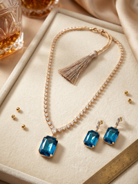 Jewelry set with blue gemstones on a beige surface