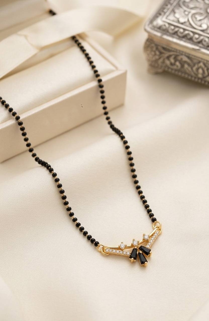 Black beaded necklace with a gold and black pendant on a beige surface