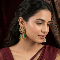 Woman wearing traditional earrings with a dark background